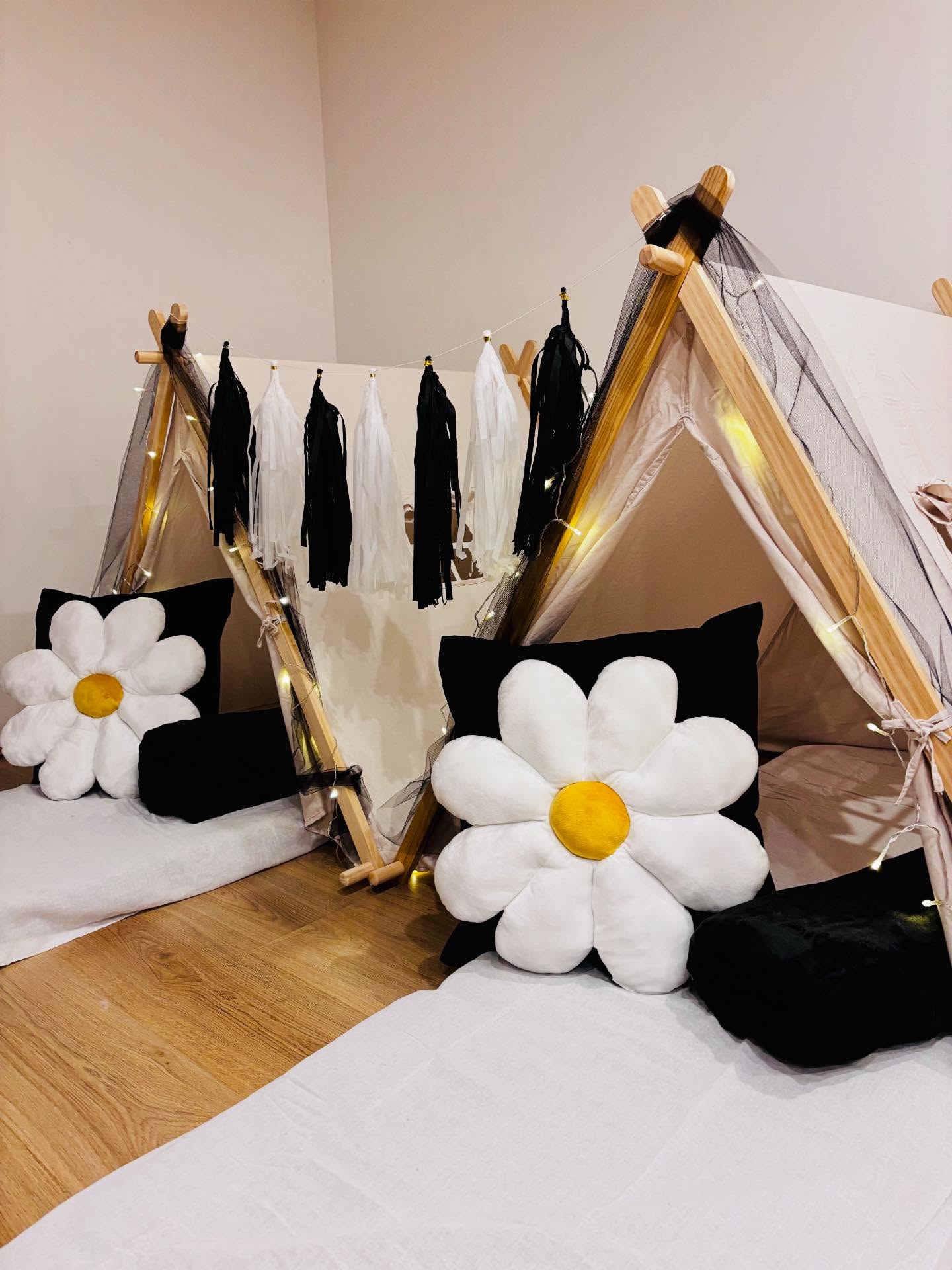 Mottotipi Daisy – Tipi mit großen Gänseblümchen-Kissen, schwarzen Akzenten und Lichterketten für die Kinder-Übernachtungsparty
